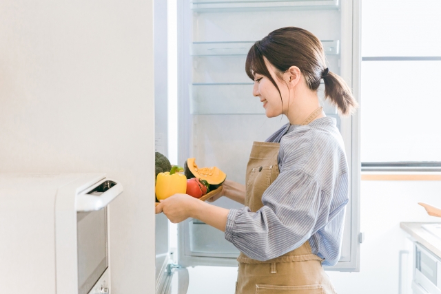 冷蔵庫の中を見る女性